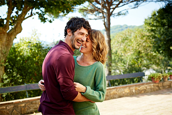 Casal apaixonado desfrutando de um jantar romântico sob a luz de velas, simbolizando as mudanças químicas e emocionais que ocorrem no corpo quando nos apaixonamos.