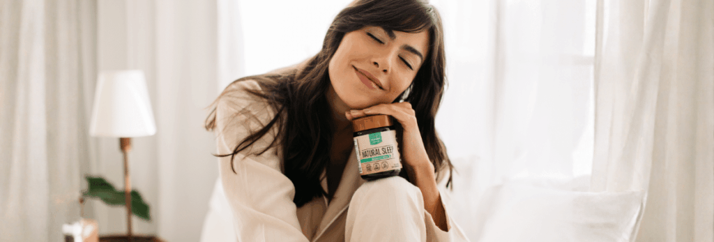 Mulher dormindo tranquilamente em um quarto escuro e confortável, simbolizando a importância da qualidade do sono.