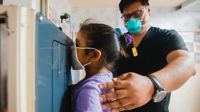 Médico analisando amostra de sangue para detectar tuberculose através de fragmentos genéticos.